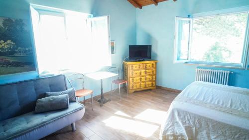 a bedroom with a bed and a tv and a couch at Rifugio Nel Bosco in Rieti
