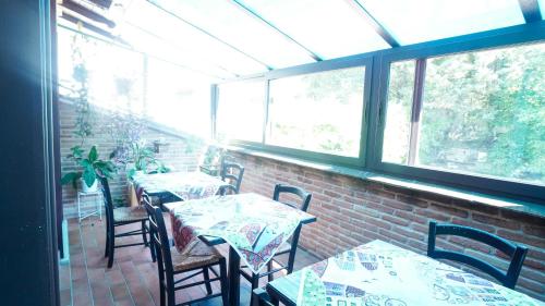 a restaurant with tables and chairs and windows at Rifugio Nel Bosco in Rieti