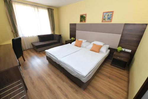 a bedroom with a large bed and a couch at Jade Hotel-Ezüsthíd Hotel in Veszprém