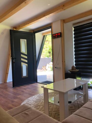 a living room with a glass table and a door at Vikednica ZEA 