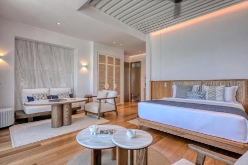 a bedroom with a large bed and a living room at Avant Mar Paros in Naousa