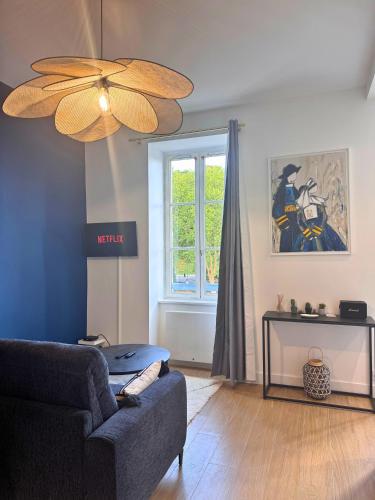 a living room with a couch and a ceiling fan at Vue Odet - calme & lit Queen Size à Quimper in Quimper