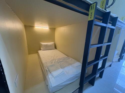 バンコクにあるNomad Yard Hostelの二段ベッドとはしごのある小さな部屋