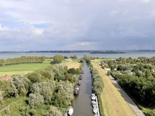 an aerial view of a canal with boats at waterland in Ooltgensplaat