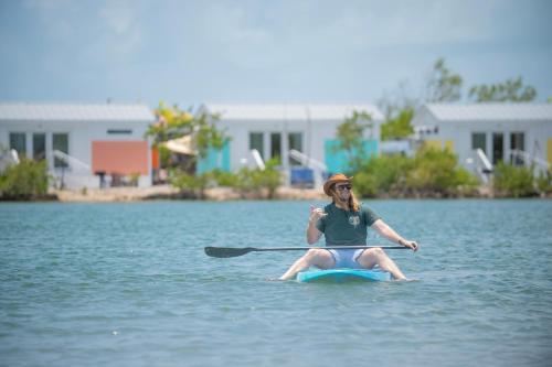 a woman is sitting on a paddle board in the water at Sugarloaf Key RV Resort & Cottages in Summerland Key