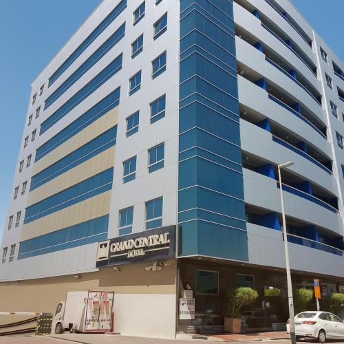 a tall building with a car parked in front of it at Grand Central Hotel in Dubai