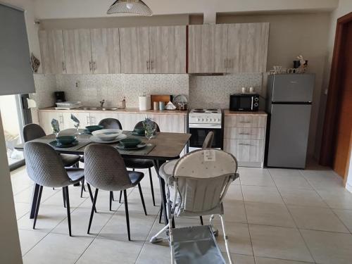 a kitchen with a table and chairs and a refrigerator at aphome in Volos