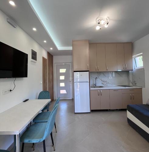 a kitchen and dining room with a table and chairs at Apartments Aura in Utjeha