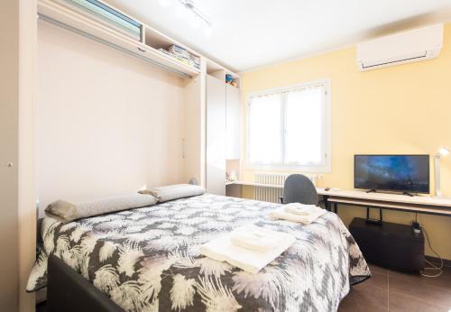 a bedroom with a bed and a desk and a television at Fra Cielo e Mare - Private parking & Wi-Fi in Castellaro