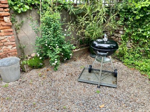 a grill sitting on a stand in a garden at 16 Bis-Gîte-Hôtel-Appartement in Marssac-sur-Tarn