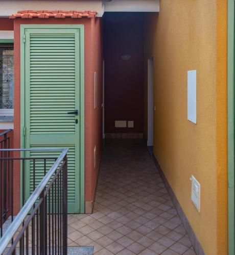 a hallway with two green doors and a staircase at Fra Cielo e Mare - Private parking & Wi-Fi in Castellaro
