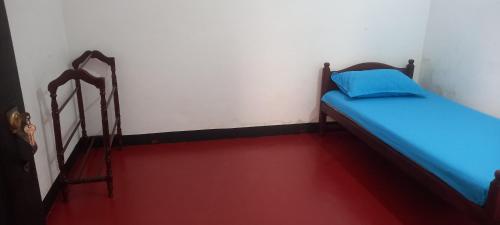 a small room with a bed and a red floor at Crown Majesty in Arugam Bay