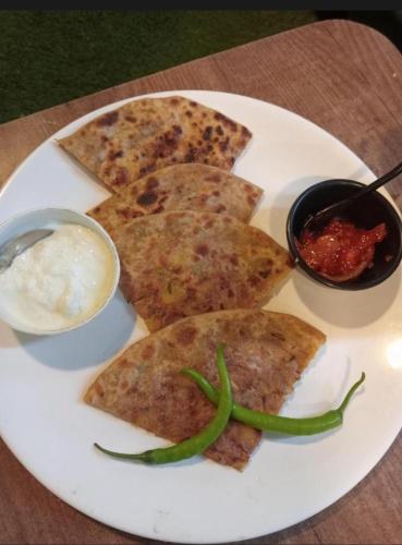 a white plate of food with some food on a table at Hotel Season in Ahmedabad