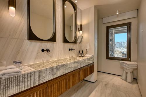 a bathroom with a sink and a large mirror at Avant Mar Paros in Naousa