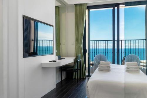 a hotel room with a view of the ocean at Capella Apartment Fireworks and Ocean View- Hillside Phu Quoc in Phu Quoc