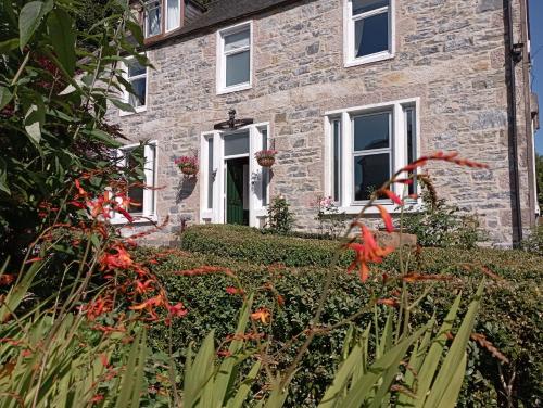 a stone house with flowers in front of it at Abbeyfield B&B in Dufftown