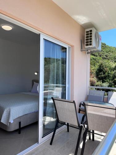 a balcony with a bed and a table and chairs at Apartments Aura in Utjeha