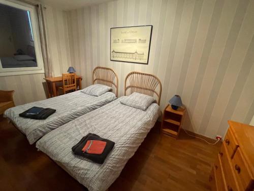 2 Betten in einem kleinen Zimmer mit 2 Stühlen in der Unterkunft "Maison de la mer" à 200 m de la plage - St Jean de Monts in Saint-Jean-de-Monts