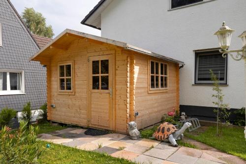 a wooden cabin in the yard of a house at Sara´s Ferienwohnung in Plettenberg