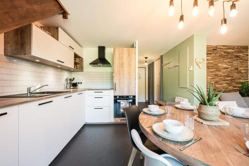 a kitchen and dining room with a wooden table and chairs at Charmant Duplex Au Pied Des Pistes in Albiez-Montrond