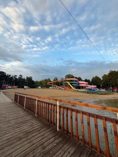 a park with a roller coaster and a playground at Domek nad rozlewiskiem in Klotyldzin