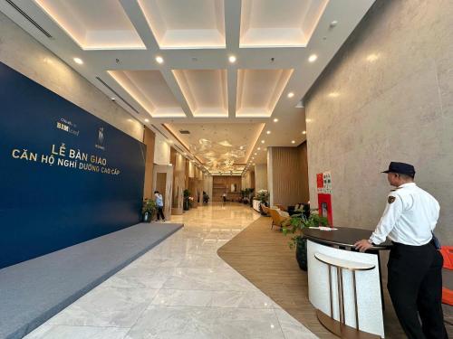 a man standing at a counter in a lobby at ICON40 Ha Long Luxury Apart in Ha Long