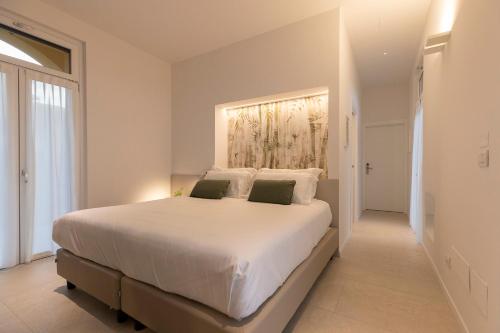 a bedroom with a large white bed with two pillows at Grow Green in Caponago