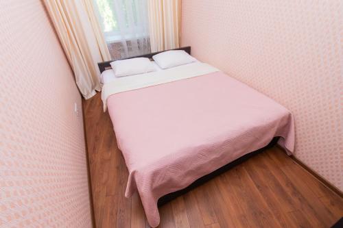 a small bedroom with a bed with white sheets and a window at Seven Apartments 66 in Vyshneve