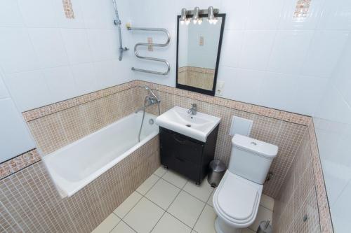 a bathroom with a tub and a toilet and a sink at Seven Apartments 66 in Vyshneve
