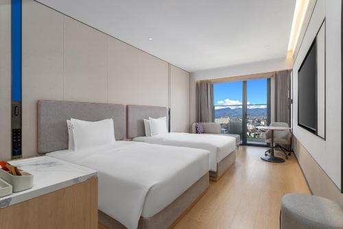 two beds in a hotel room with a view at Holiday Inn Express Lijiang Ancient Town by IHG in Lijiang
