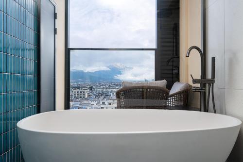 a bath tub in a bathroom with a window at Holiday Inn Express Lijiang Ancient Town by IHG in Lijiang