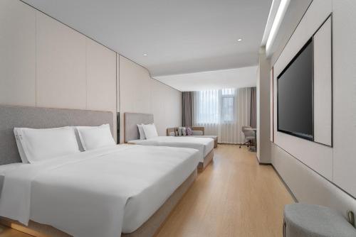 a hotel room with two beds and a flat screen tv at Holiday Inn Express Lijiang Ancient Town by IHG in Lijiang