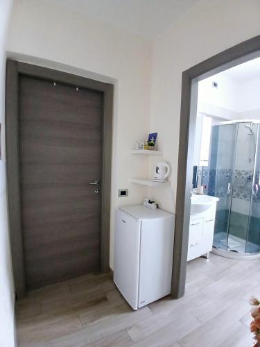 a door to a bathroom with a refrigerator and a sink at B&b Il Giardinetto in Selargius