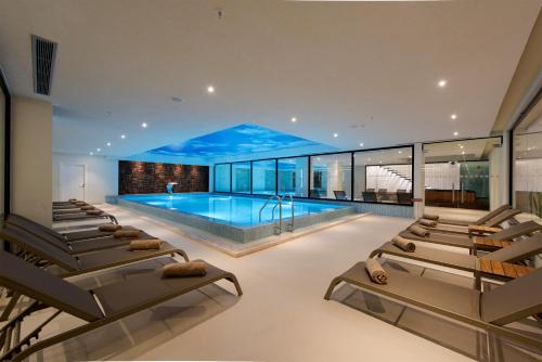 a swimming pool with chaise lounge chairs in a house at Flora Garden Ephesus Kusadasi - All Inclusive in Davutlar