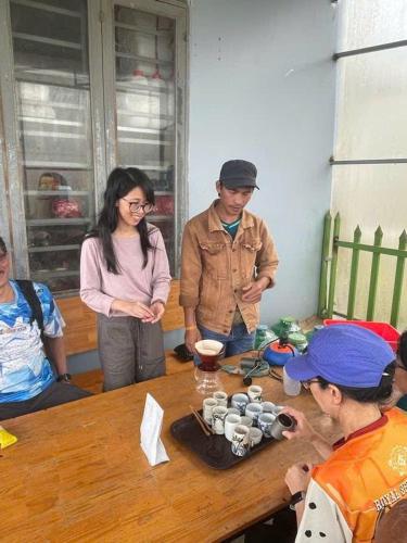 a group of people standing around a wooden table at MAI HICH FARMSTAY 2 in Mai Hạ