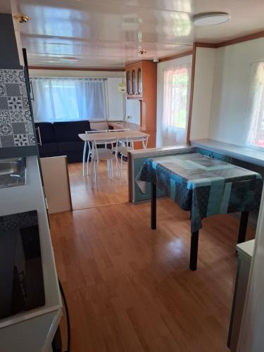chalet cosy في لو كاستليت: مطبخ وغرفة معيشة مع طاولة وكراسي