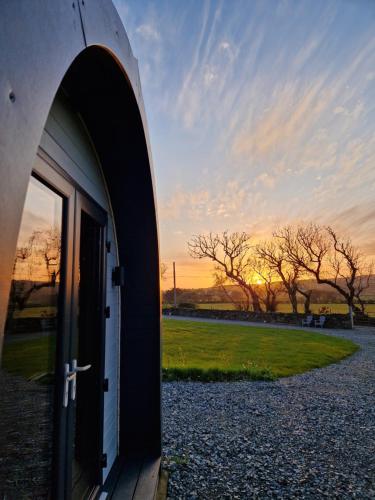 a door to a building with a sunset in the background at Culdaff Estate Glamping in Culdaff