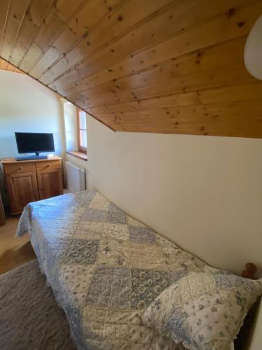 a bedroom with a bed and a wooden ceiling at Chata Snowland in Valča