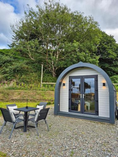 a small shed with a table and chairs at Culdaff Estate Glamping in Culdaff
