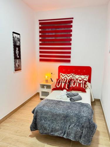 a bedroom with a bed with a red headboard at Casa en Villa Romero in Alora