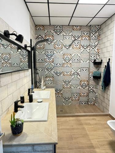a bathroom with two sinks and a tiled wall at Casa en Villa Romero in Alora