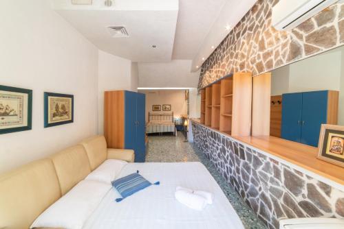a bedroom with a bed and a stone wall at Hotel Pietra Verde in Otranto