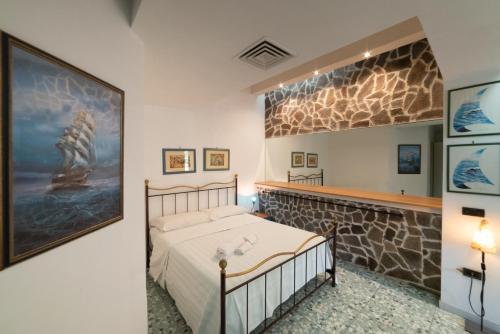 a bedroom with a bed and a stone wall at Hotel Pietra Verde in Otranto