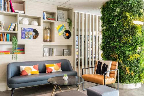 a living room with a blue couch and a plant at ibis Paris Porte de Montreuil in Paris