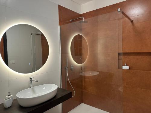 a bathroom with a sink and a shower with a mirror at Mater in Capilungo