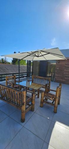 two wooden benches sitting under an umbrella at Dava&Davi in Ureki