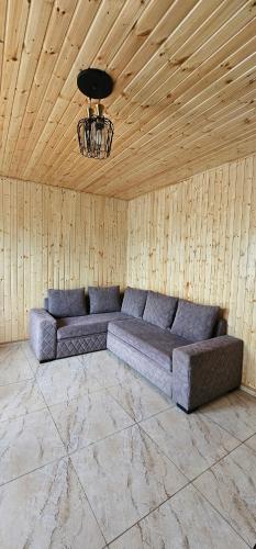 a couch in a room with a wooden ceiling at Dava&Davi in Ureki