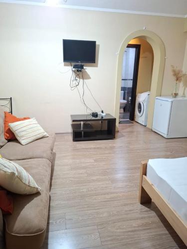 a living room with a couch and a flat screen tv at Aura Plaza Hotel in Tbilisi City