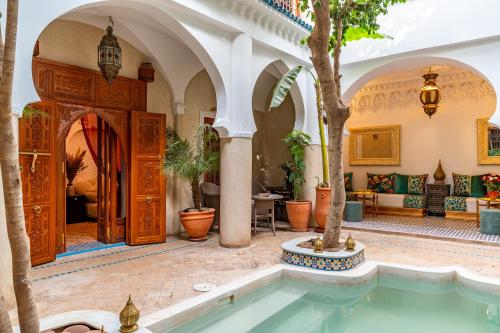 a house with a swimming pool in a courtyard with trees at Riad Asrari in Marrakech