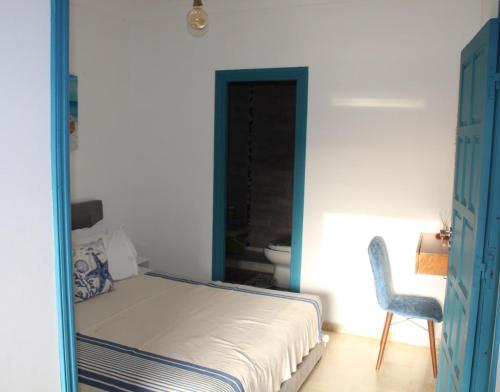 a bedroom with a bed and a chair in it at K Playa Vibe Darbouazza in Dar Bouazza